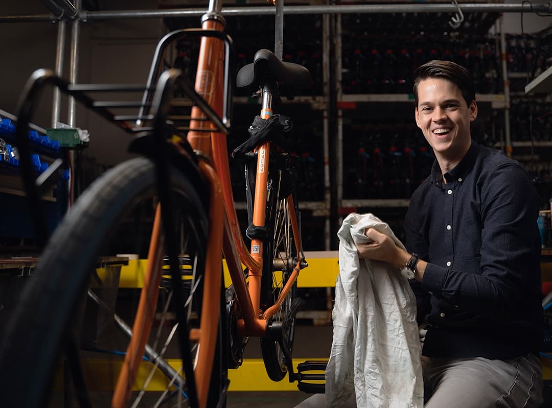 Man holding a towel next to an orange bike