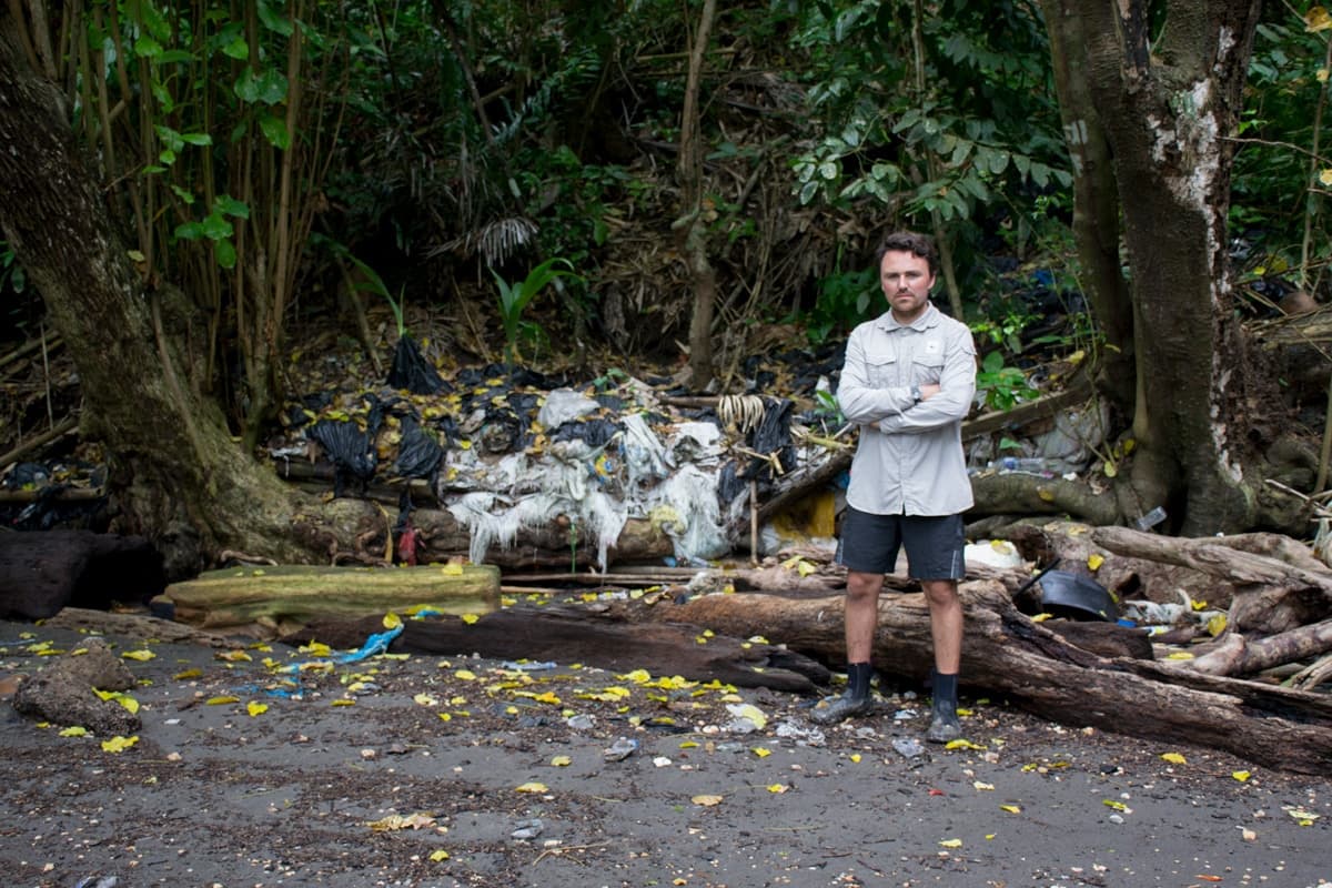 Man in front of small waterfall in the forest