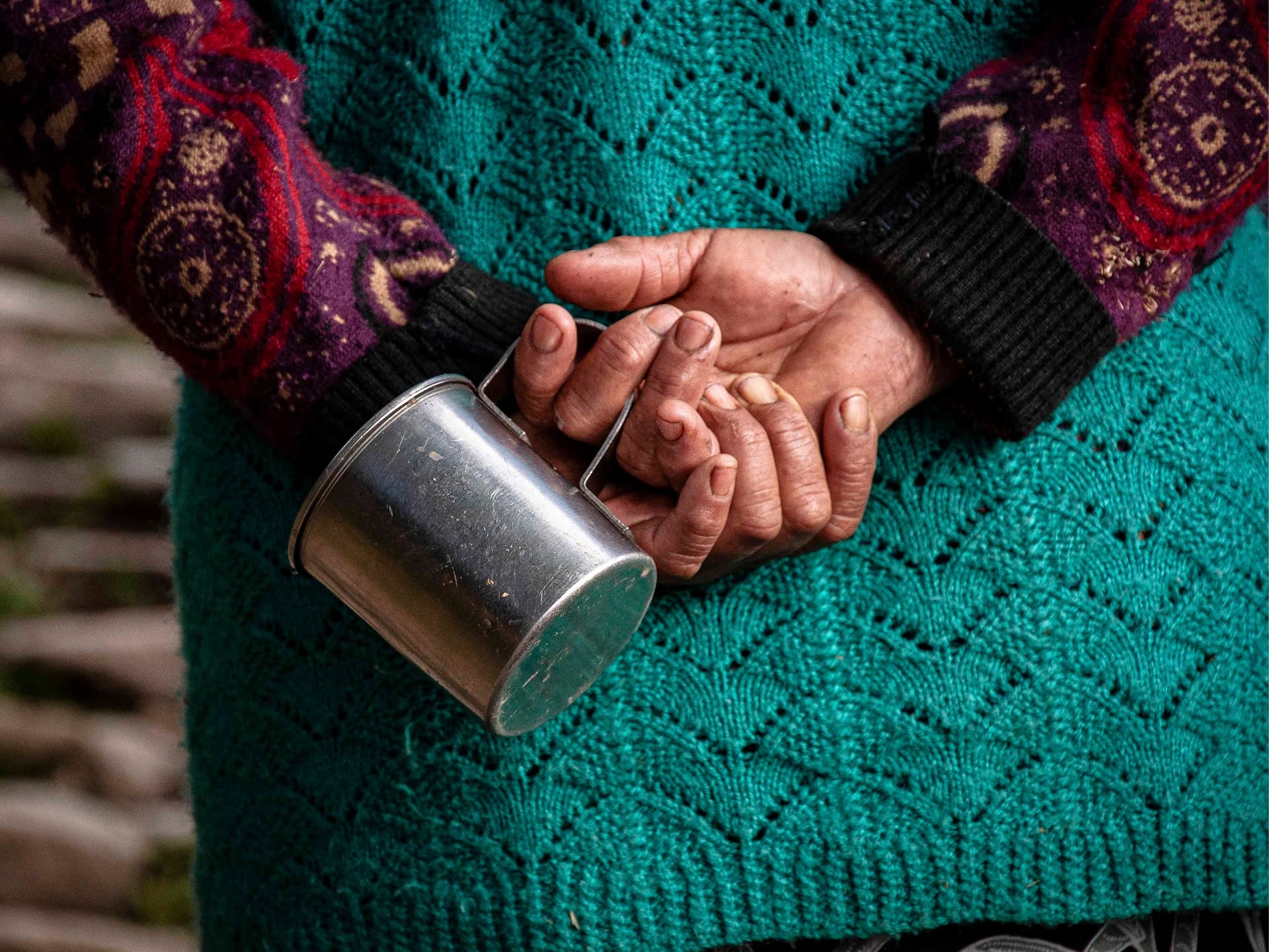 Nepalese person holding a steel mug