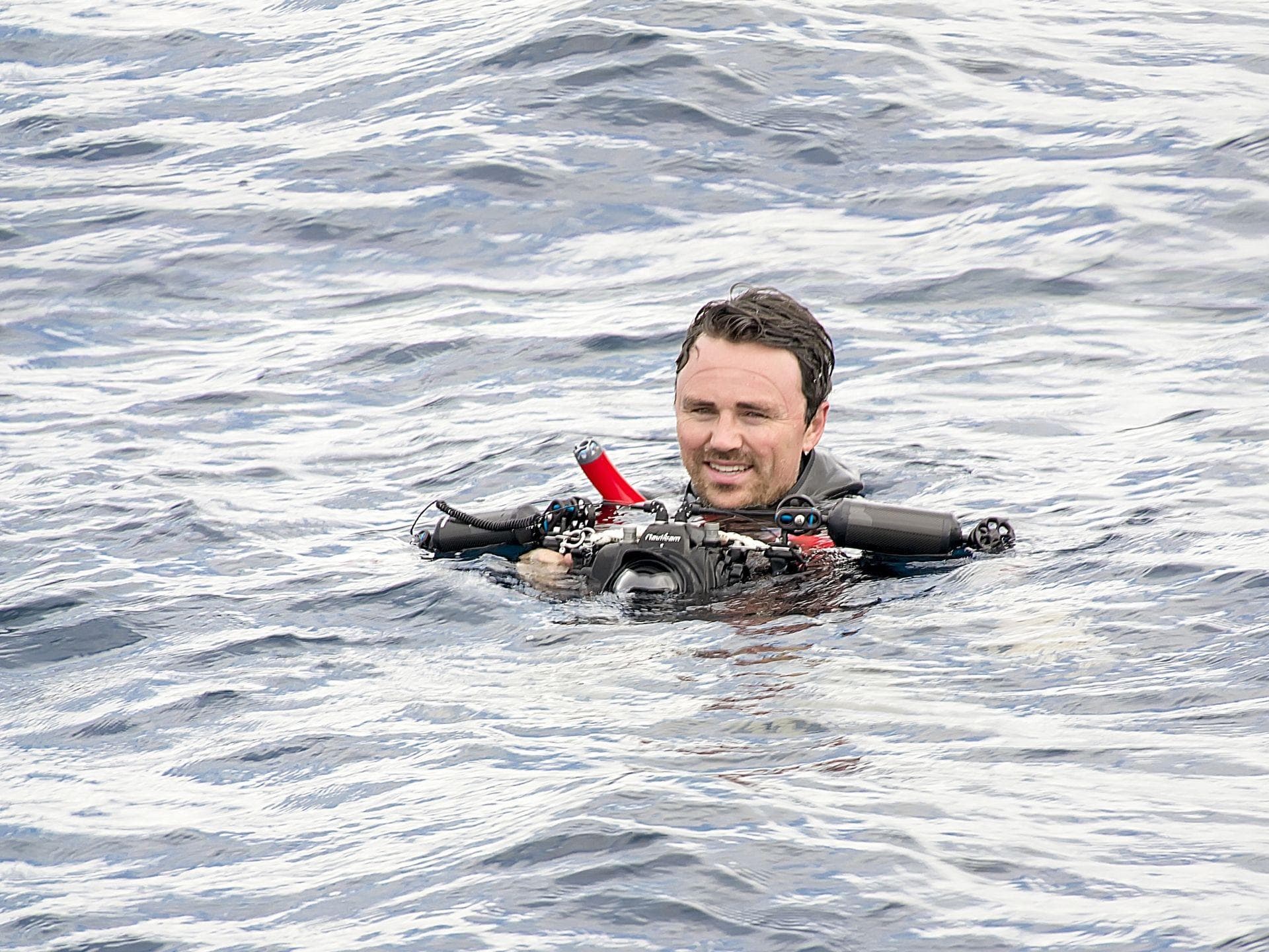 Man in the sea holding a camera