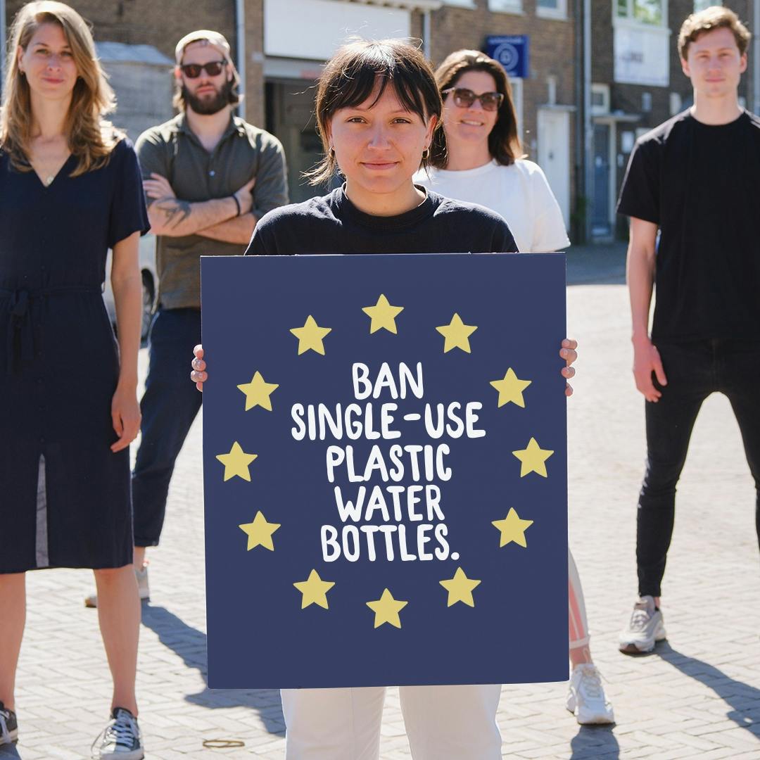 Holding a sign Ban signle-use plastic water bottles